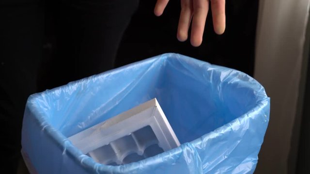 Girl throwing chocolate sweets into household plastic trash bin. Environmental Impact of Food Waste. Healthy eating