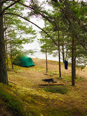 the tent stands on the shore of forest lake  © Olga