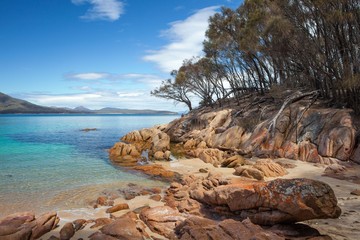 The Freycinet peninsula is a place of vibrant color - orange lichen and clear aqua coloured water.