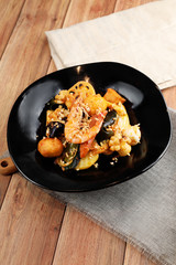 Fried fresh shrimp and black fungus in a dark ceramic dish