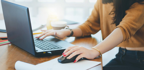 Closeup of hand young asian businesswoman using laptop working in office
