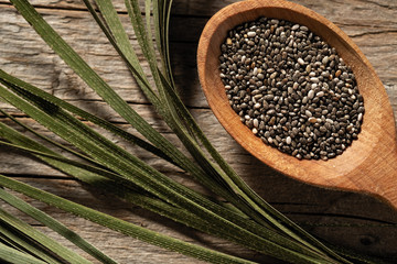 chia seeds in dishes on wooden background, view from above
