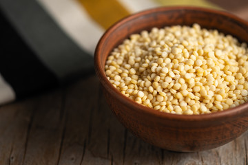 couscous croup in a clay bowl on a wooden background