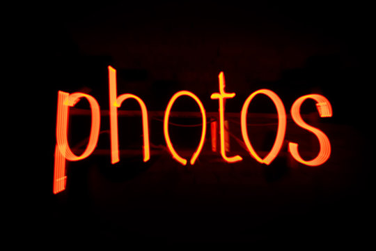 Blur Photos message in red neon against black background - Image