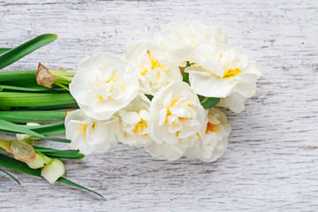 White narcissus flowers on wooden background.