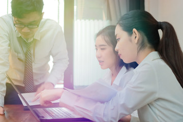 Teamwork business concept. Group of Asian people working with laptop together in modern office. Selective focus and shallow depth of field.