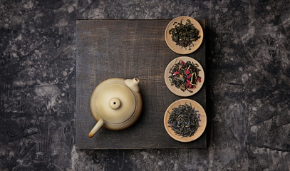 tea ceremony concept, Chinese or japanese traditions. teapot, cup of tea on dark background, several kinds of tea welding. variety of tea selection. Asia culture design concept. Top view, copy space