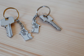 Two keys with splitted or broken key rings with pendant in shape of house divided in two parts on...
