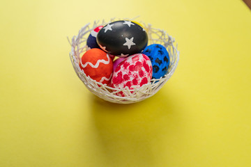 easter eggs on yellow background in flat lay with copy space