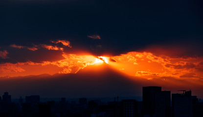 Fototapeta premium 都心から見える遥か彼方の山並みと沈む太陽