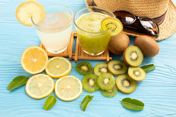 glass of lemon juice white lime and kiwi juice on blue wood background