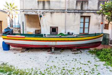 Fototapeta na wymiar Small Typical Sicilian Fishing Boat by a House