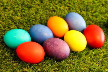 Fototapeta na wymiar bunch of colorful bright easter eggs in the green grass