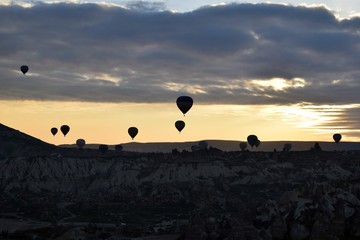 Sunrise and balloons. Beautiful background of the balloon and the sunset.Cappadocia. Turkey. Göreme. Nevşehir. Türkiye. 8. 04. 2019. Balloons flying over the rocky landscape in Cappadocia Turkey. 