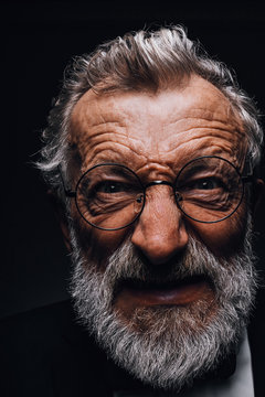 Mature Man With Angry Grimace On Face Revealing In Screwed-up Eyes, Evil Wicked Smile And Old Deep Wrinkles Close-up. Human Emotions And Facial Expressions Concept.