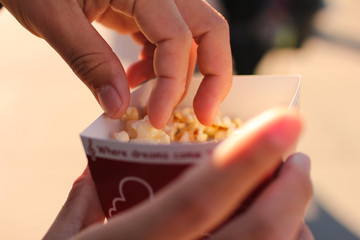 ポップコーンをつまむ手