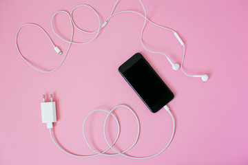Top view of a smartphone with headphones and charge.