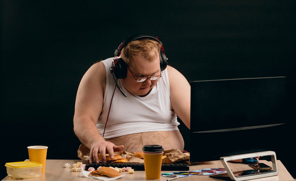 Young Man With Bad Habbits. Guy Is Sitting In Front Of Computer And Staring At The Screen.laziness,day Off, Holiday. Daily Routine