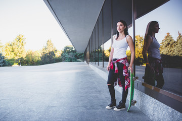 Beautiful woman with a skateboard on the street