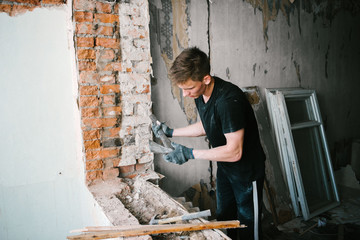 A man works with an ax and a hammer