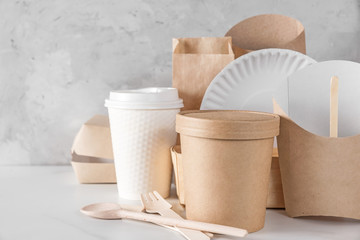 eco friendly disposable dishes made of bamboo wood and paper on white marble background. recycling...
