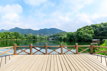 Wooden floor platform and lake with green mountains background in Hangzhou