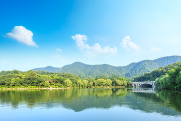 Fototapeta na wymiar Green mountain and calm lake natural scenery in Hangzhou