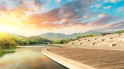 Fototapeta premium Wooden floor platform and lake with green mountains background in Hangzhou