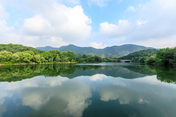 Fototapeta na wymiar Green mountain and calm lake natural scenery in Hangzhou