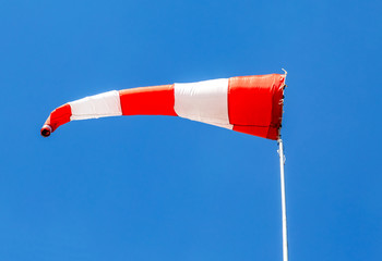 Flying windsock wind vane with red and white lines