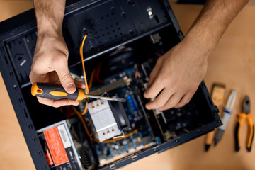 Technician fixing problem with PC Mid adult man, computer maintenance technician,top view close up...