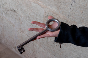 hand holding giant iron medieval key