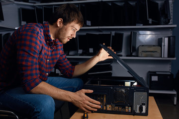 young man cares of the computer, close up side view photo. on-site computer service