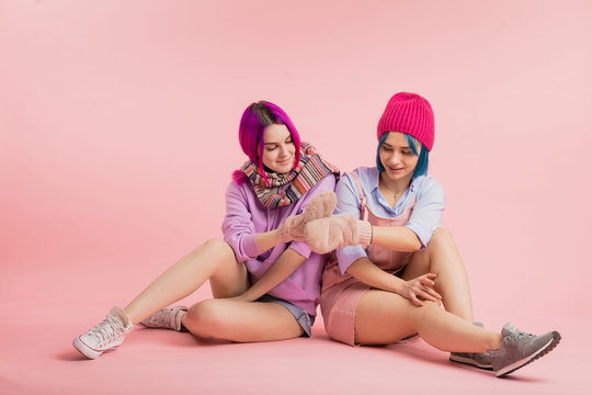 funny awesome girls with mittens on their hands. best lovely women having fun while sitting on the floor.full length photo. best friends support each other in any situation, common ideas and interests
