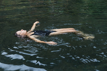 A young girl swims in the pool.