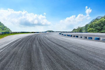 Asphalt race track ground and mountains with blue sky landscape