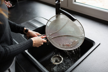 The girl prepares food in the kitchen. Hands close-up