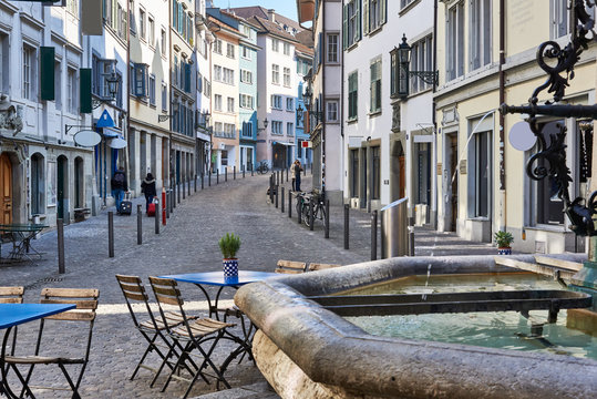 Z&uuml;rich Neumarkt, Z&uuml;rcher Altstadt, historische St&auml;tte, alte H&auml;user,  Teil des Nike-Brunnens, Gartentische, Gartenst&uuml;hle