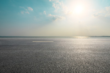 Empty asphalt road and blue sea with sky background