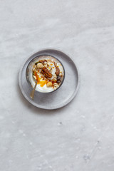 Fototapeta na wymiar Granola with yogurt, honey and chocolate bars on marble table with copy space
