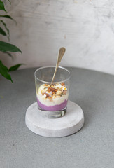 Granola with yogurt, honey and chocolate bars on marble table with copy space