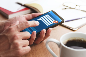 Notification icon on smartphone screen.Closeup of male hands touching smartphone screen at table.