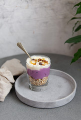 Granola with yogurt, honey and chocolate bars on marble table with copy space