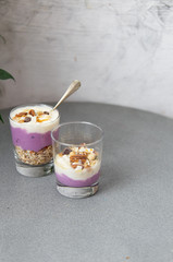 Granola with yogurt, honey and chocolate bars on marble table with copy space