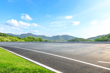 Empty asphalt road and mountains with blue sky on a sunny day
