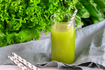 Freshly blended green smoothie in in a glass with straws on the table. Detox vegetable juice....
