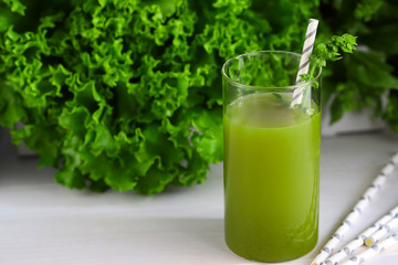 Freshly blended green smoothie in in a glass with straws on the table. Detox vegetable juice. Healthy lifestyle concept. Raw drink for vegan diet.