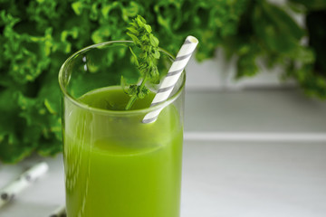 Freshly blended green smoothie in in a glass with straws on the table. Detox vegetable juice....