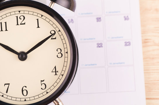Time management concept, close-up image of  alarm clock on wooden desk