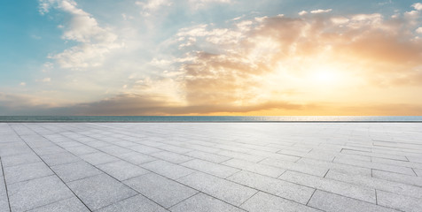 Empty square floor and blue sea with sky clouds at sunset © ABCDstock